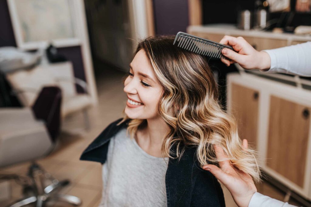 Stylist styling a client's hair at Indulge hair salon in Carrollton, GA